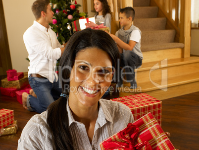 Hispanic family exchanging gifts at Christmas