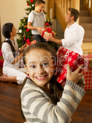 Hispanic family exchanging gifts at Christmas