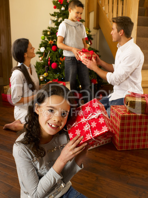 Hispanic family exchanging gifts at Christmas