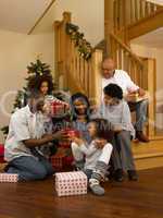 African American family exchanging Christmas gifts