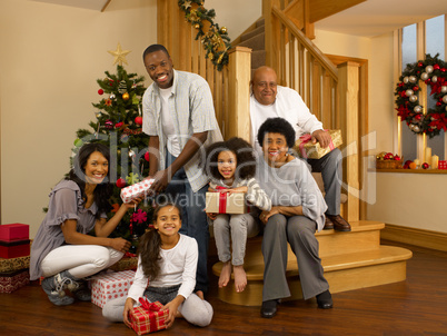 Mixed race family with Christmas tree and gifts