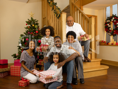 Mixed race family with Christmas tree and gifts