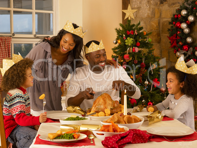 Mixed race family having Christmas dinner