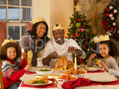 Mixed race family having Christmas dinner