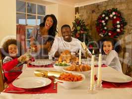 Mixed race family having Christmas dinner