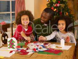 African American father making Christmas cards with children