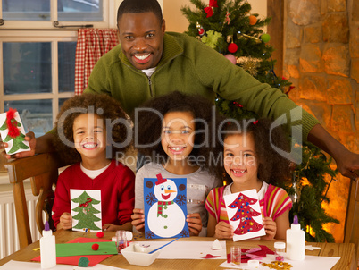 African American father making Christmas cards with children