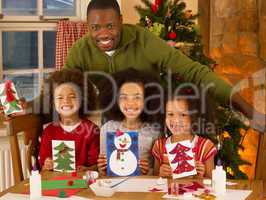 African American father making Christmas cards with children