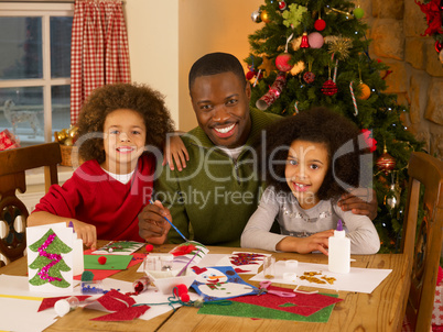 African American father making Christmas cards with children