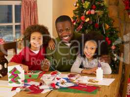 African American father making Christmas cards with children