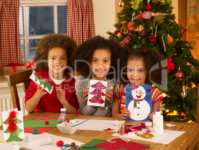 Mixed race children making Christmas cards