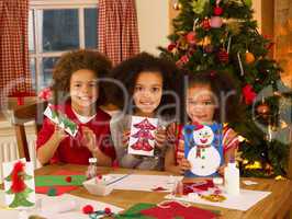 Mixed race children making Christmas cards