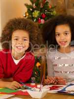 Mixed race children making Christmas cards