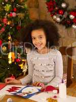 Mixed race child making Christmas cards