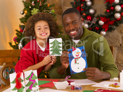 African American father and mixed race son making Christmas card