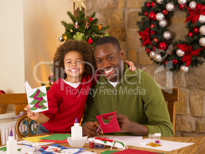 African American father and mixed race son making Christmas card