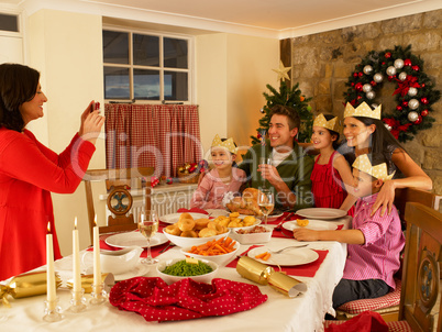 Hispanic family taking photos of Christmas dinner