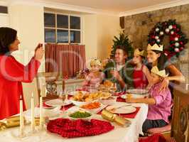 Hispanic family taking photos of Christmas dinner