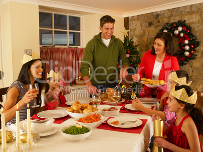Hispanic family serving Christmas dinner