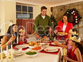 Hispanic family serving Christmas dinner