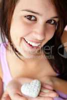 Teenage girl holding silver heart