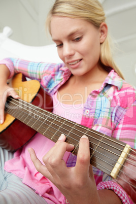 Teenage girl playing acoustic guitar
