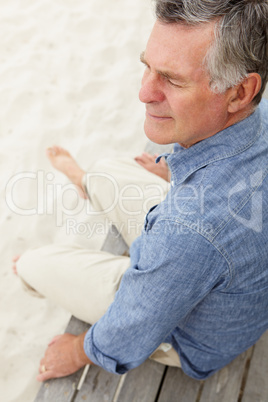 Senior man sitting by beach