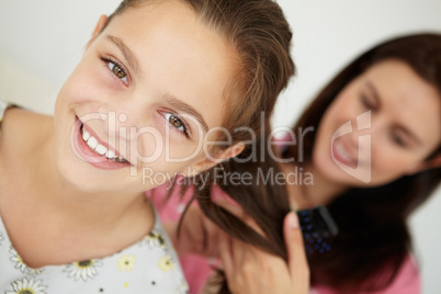 Mother brushing daughter's hair