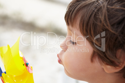 Young boy blowing on windmill