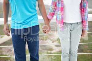 Teenage girl and boy holding hands