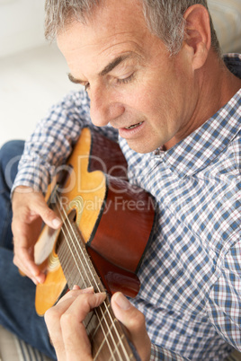 Mid age man playing acoustic guitar