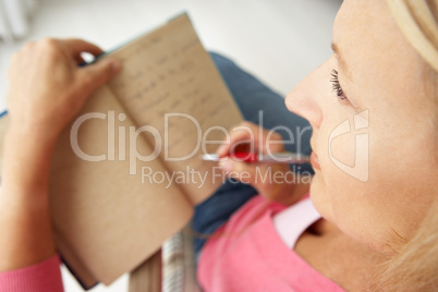 Senior woman writing in notebook