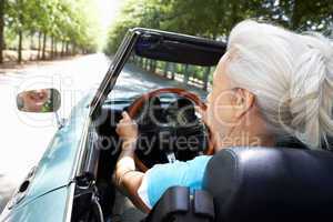 Senior woman in sports car