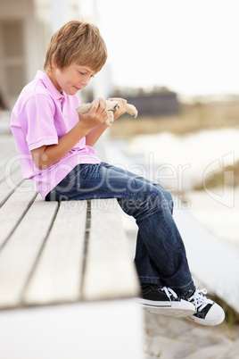 Young boy outdoors holding starfish