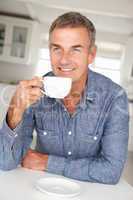 Mid age man with coffee at home