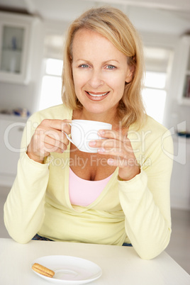 Mid age woman with coffee at home