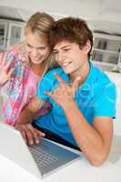 Teenage boy and girl using laptop