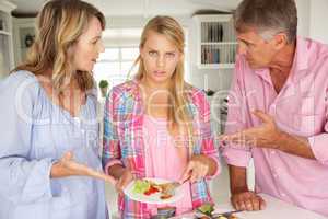 Parents making teenage daughter do chores at home