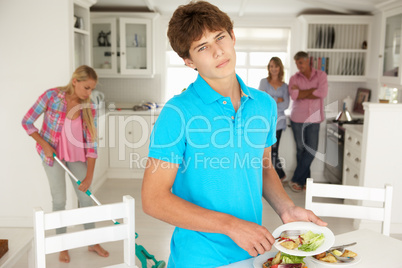 Teenagers reluctantly doing housework