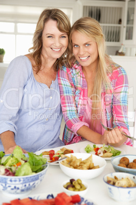 Mother and teenage daughter enjoying meal at home