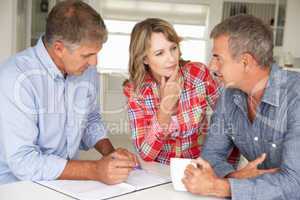 Mid age couple with financial advisor at home