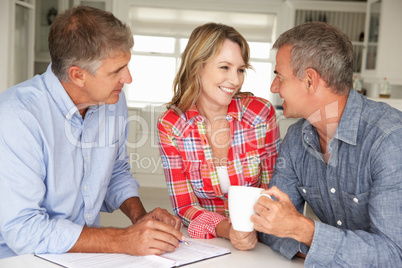 Mid age couple with financial advisor at home