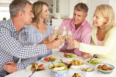 Mid age couples enjoying meal at home