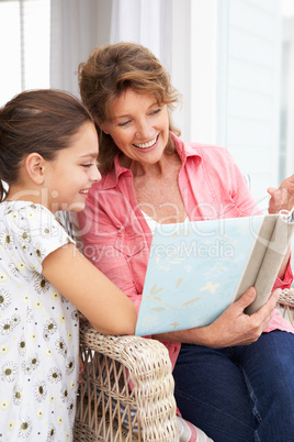 Senior woman and granddaughter with photo album