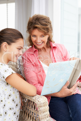 Senior woman and granddaughter with photo album
