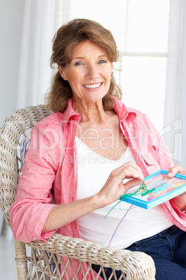 Senior woman doing cross stitch