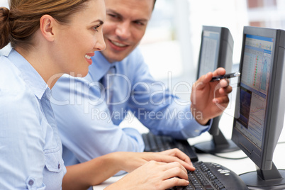Business man and woman working on computers