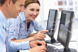 Businessman and woman working on computers