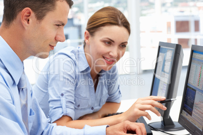 Businessman and woman working on computers