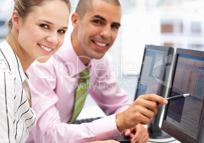 Businessman and woman working on computers